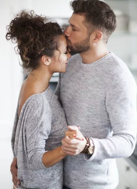 Man kissing his girlfriend in forehead